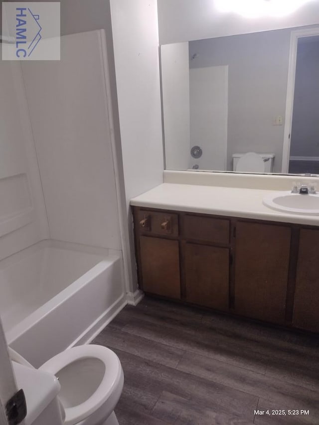 bathroom with toilet, wood finished floors, and vanity