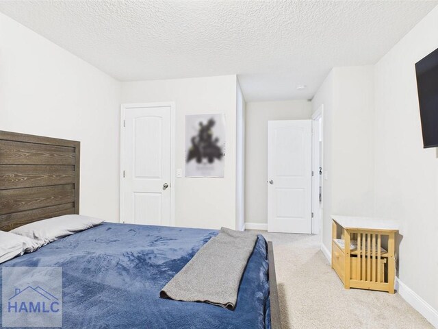 carpeted bedroom featuring a textured ceiling and baseboards