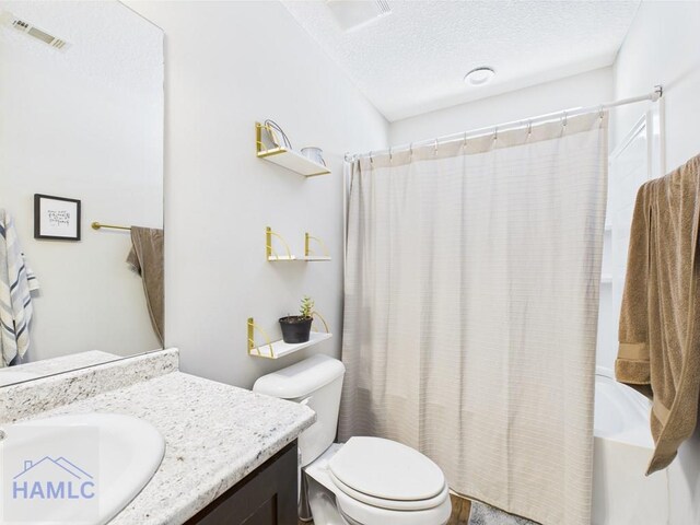bathroom with a textured ceiling, visible vents, shower / bath combo, vanity, and toilet