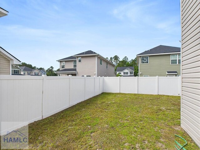 view of yard featuring a fenced backyard and a residential view