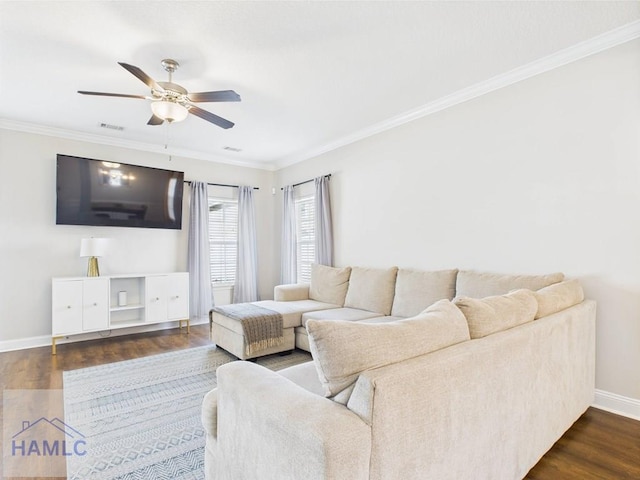 living area featuring baseboards, ornamental molding, a ceiling fan, and dark wood-style flooring