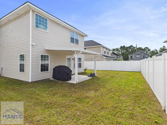 rear view of property featuring a fenced backyard, a patio, and a lawn