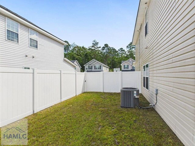 view of yard featuring a fenced backyard and central AC