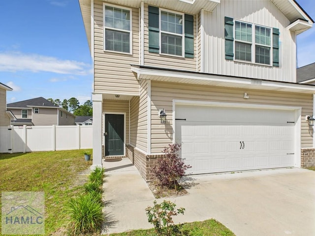 view of front of property with board and batten siding, a garage, fence, a front lawn, and concrete driveway