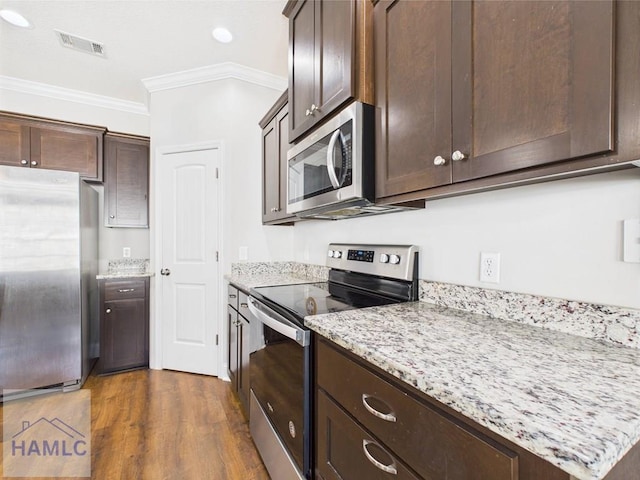 kitchen featuring visible vents, ornamental molding, dark brown cabinets, dark wood finished floors, and stainless steel appliances