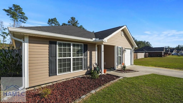 view of front of home featuring concrete driveway, fence, a garage, and a front yard