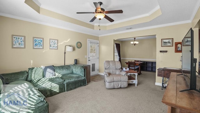 living room with a tray ceiling, carpet flooring, ceiling fan with notable chandelier, and visible vents
