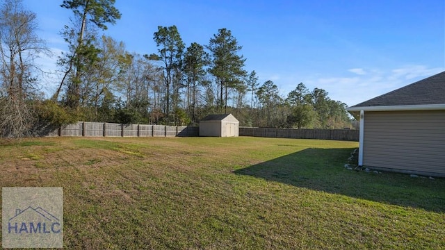 view of yard with an outbuilding, a storage shed, and a fenced backyard