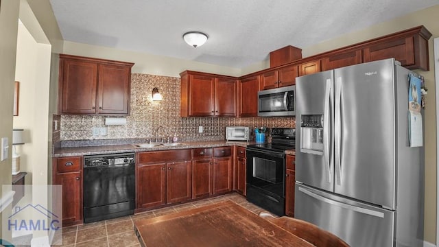 kitchen with a toaster, a sink, black appliances, tasteful backsplash, and reddish brown cabinets