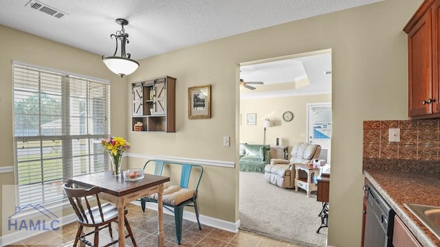 dining room with tile patterned flooring, visible vents, baseboards, a textured ceiling, and a ceiling fan