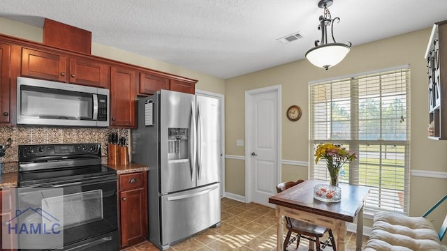 kitchen with visible vents, decorative backsplash, stainless steel appliances, a textured ceiling, and reddish brown cabinets
