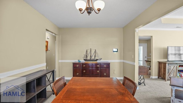 dining space featuring baseboards, carpet floors, and a notable chandelier