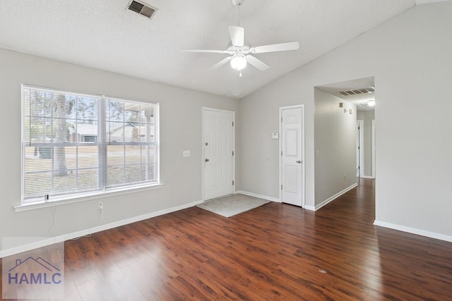 unfurnished room featuring ceiling fan, dark hardwood / wood-style flooring, lofted ceiling, and a textured ceiling