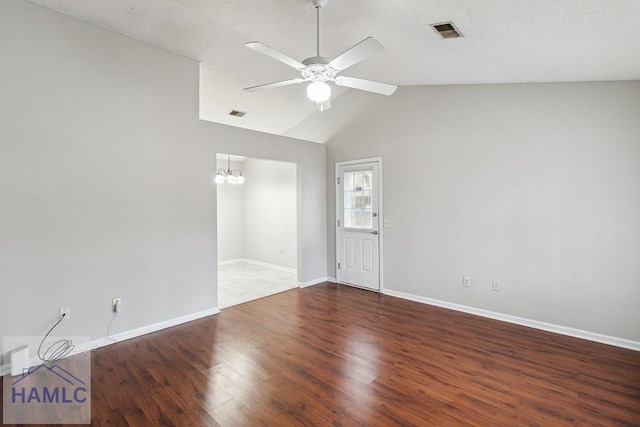 unfurnished room featuring a textured ceiling, lofted ceiling, ceiling fan with notable chandelier, and dark hardwood / wood-style floors