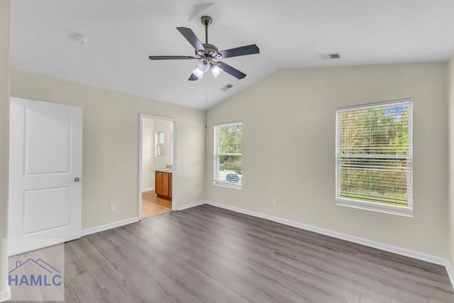 unfurnished bedroom featuring connected bathroom, multiple windows, ceiling fan, and light hardwood / wood-style floors