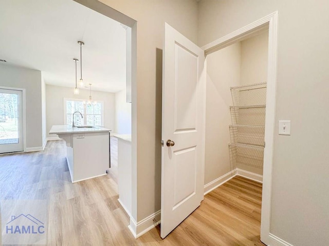 corridor featuring sink and light hardwood / wood-style flooring