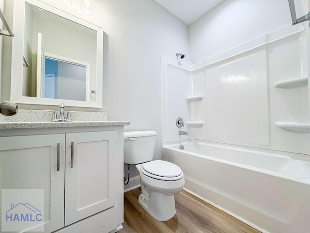 full bathroom featuring toilet, hardwood / wood-style floors, vanity, and shower / bathing tub combination