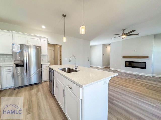 kitchen featuring appliances with stainless steel finishes, decorative light fixtures, sink, and white cabinets