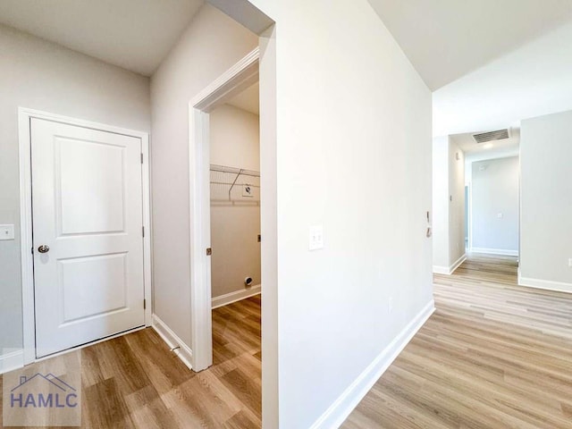 hall featuring light hardwood / wood-style flooring and vaulted ceiling