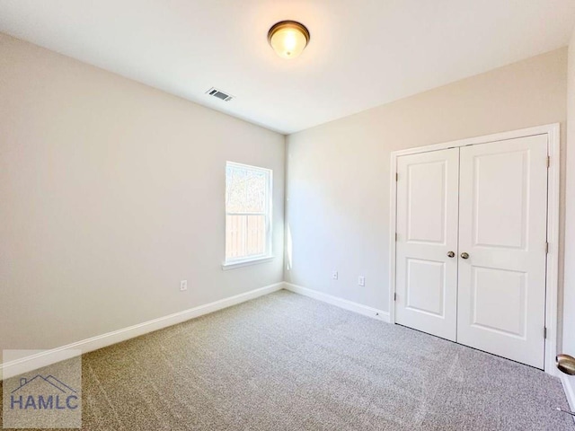 unfurnished bedroom featuring carpet floors and a closet