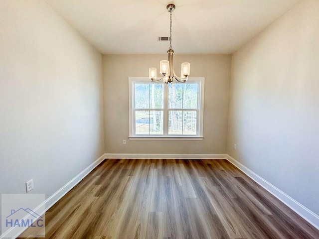 unfurnished dining area with an inviting chandelier and wood-type flooring