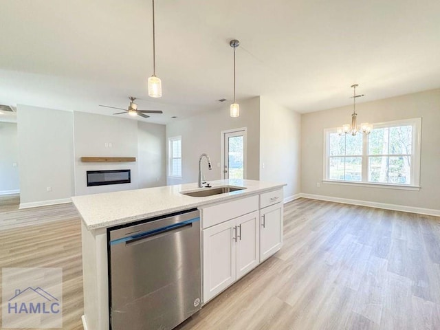 kitchen featuring dishwasher, sink, hanging light fixtures, and white cabinets