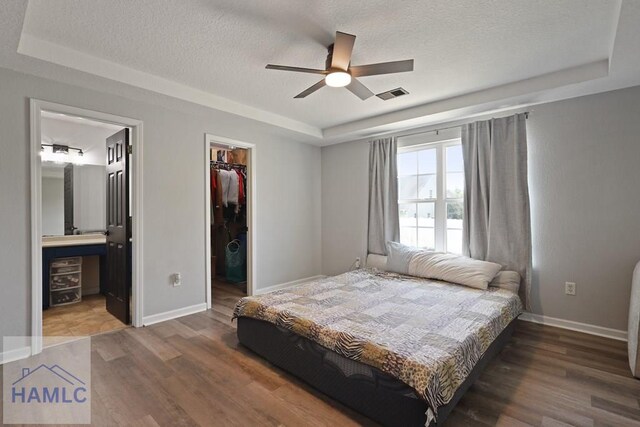 413 E Banks St, Glennville, GA 30427 - bedroom with a raised ceiling, a textured ceiling, wood finished floors, and a spacious closet