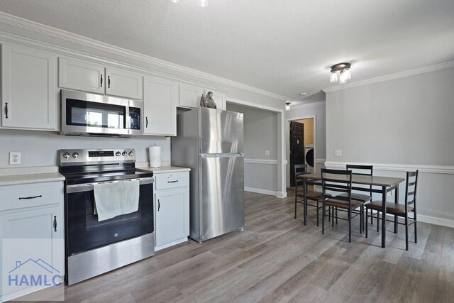 413 E Banks St, Glennville, GA 30427 - kitchen with appliances with stainless steel finishes, crown molding, light wood-type flooring, and light countertops