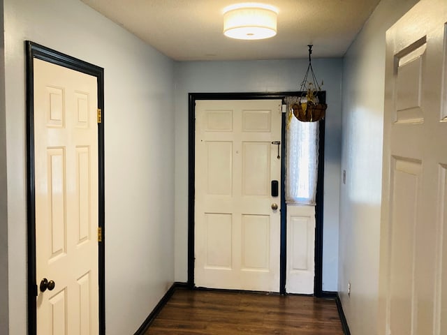 doorway featuring a chandelier, dark wood-type flooring, and a textured ceiling