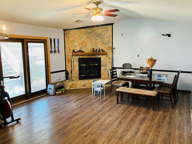 dining area with hardwood / wood-style flooring, a stone fireplace, and ceiling fan