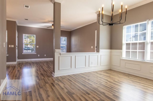 unfurnished room with wood finished floors, a wainscoted wall, visible vents, crown molding, and ceiling fan with notable chandelier