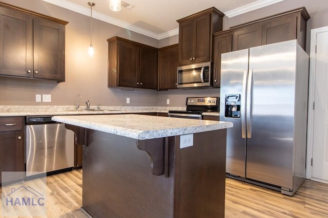 kitchen featuring ornamental molding, a sink, dark brown cabinetry, appliances with stainless steel finishes, and light wood finished floors