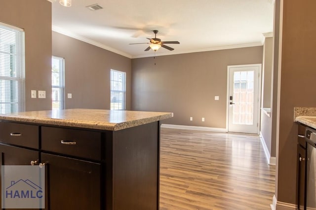 kitchen featuring visible vents, light wood-style flooring, dark brown cabinetry, crown molding, and ceiling fan