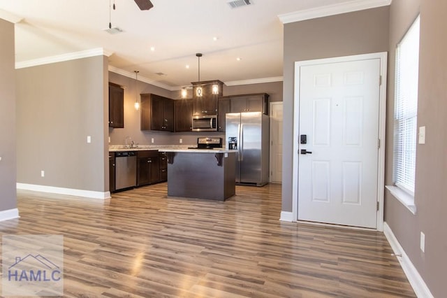 kitchen with a kitchen breakfast bar, wood finished floors, a center island, stainless steel appliances, and dark brown cabinetry