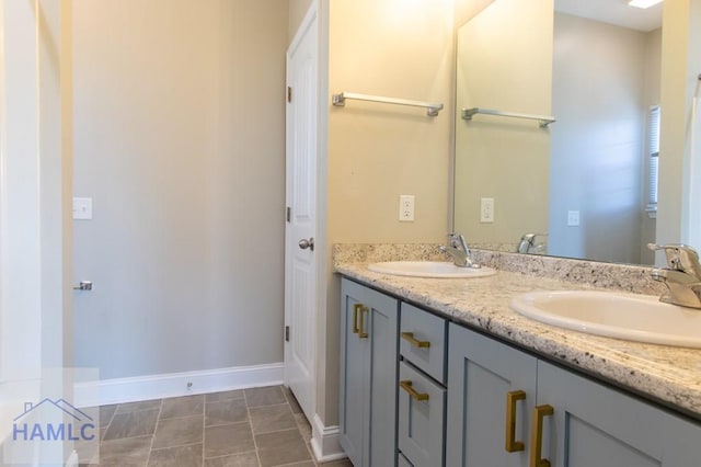 bathroom featuring double vanity, baseboards, and a sink