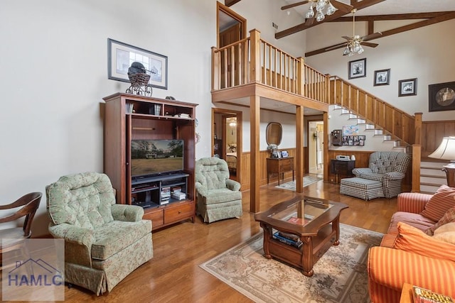 living room with beamed ceiling, ceiling fan, wood-type flooring, and high vaulted ceiling