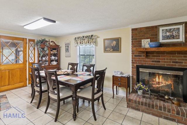 dining space with crown molding, light tile patterned flooring, a brick fireplace, and a textured ceiling