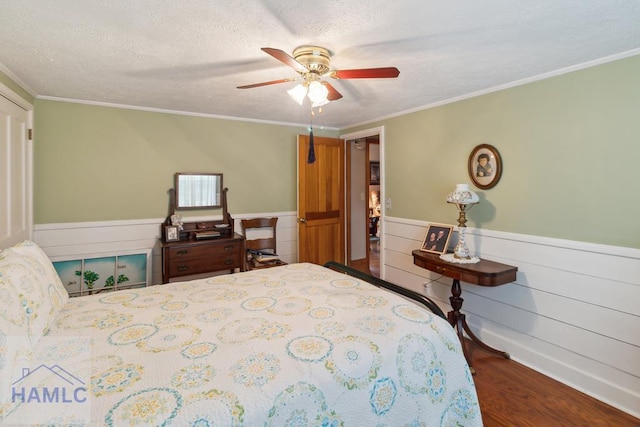 bedroom with crown molding, wood-type flooring, a textured ceiling, and ceiling fan