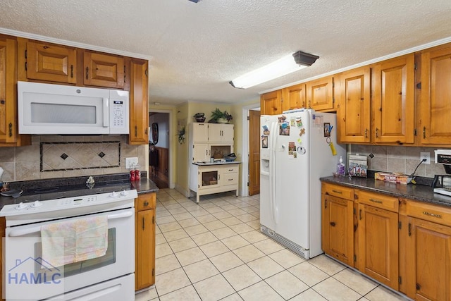 kitchen featuring a textured ceiling, white appliances, and decorative backsplash