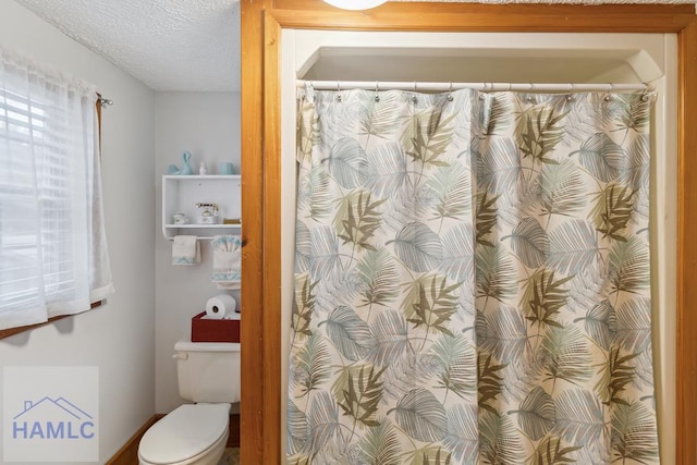 bathroom with toilet and a textured ceiling