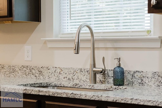 room details featuring light stone counters and sink