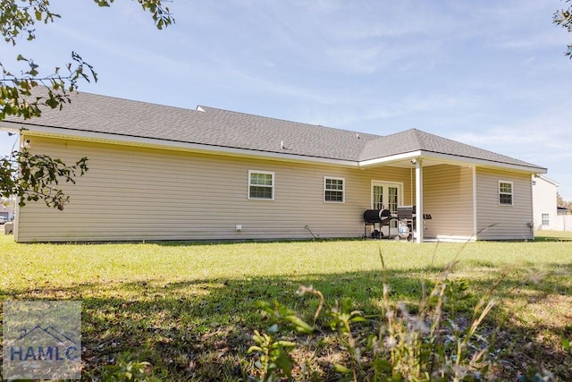 rear view of property with french doors and a yard