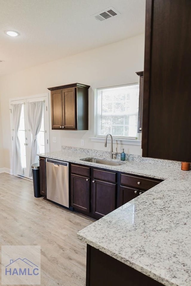 kitchen featuring dishwasher, light stone countertops, sink, and light hardwood / wood-style flooring