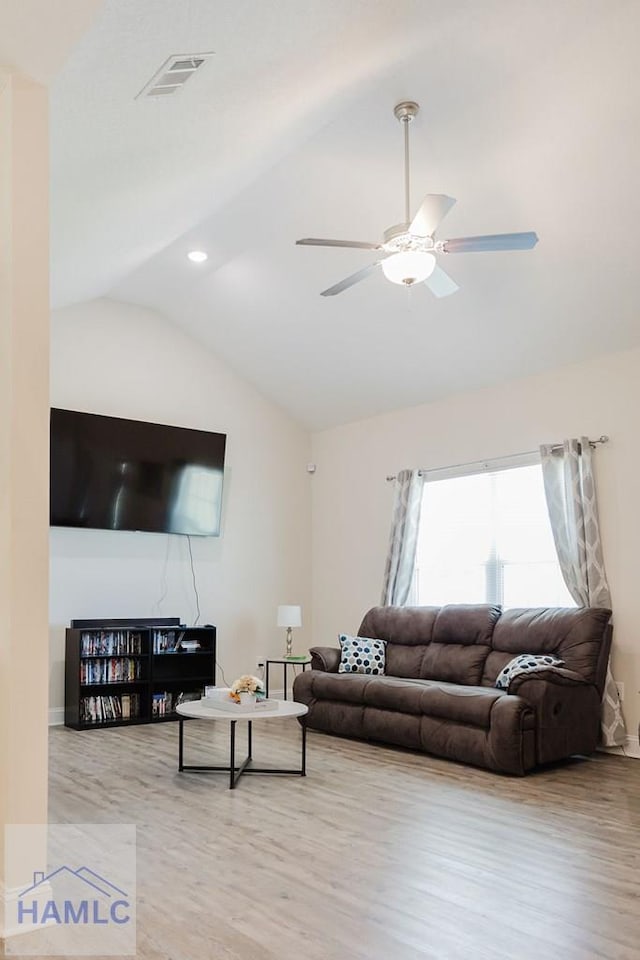 living room with light hardwood / wood-style flooring, ceiling fan, and lofted ceiling