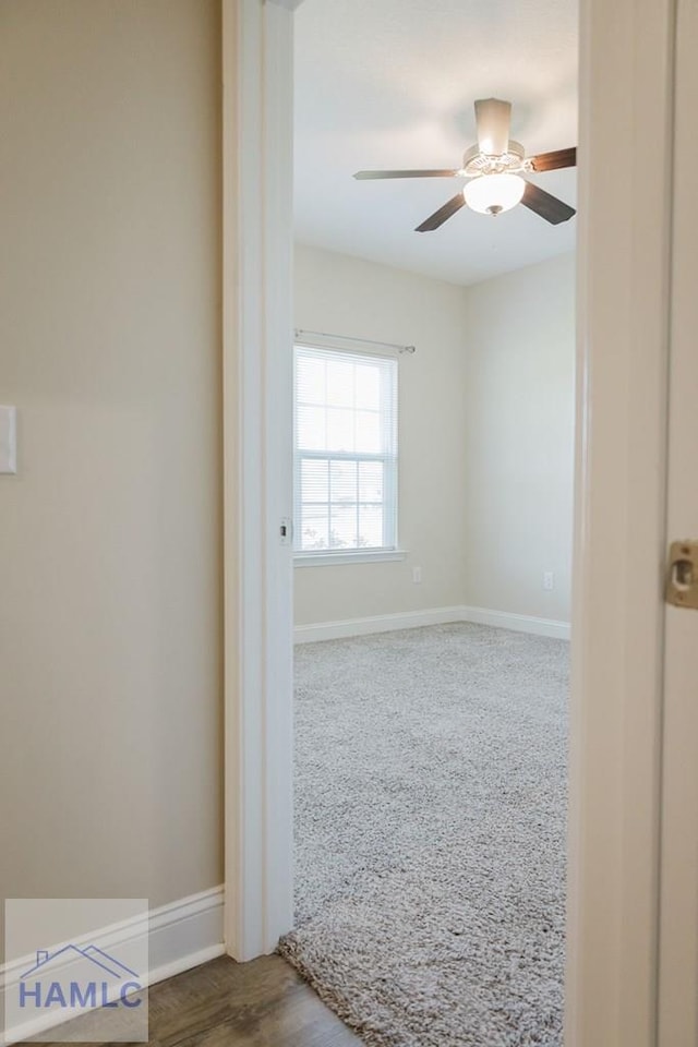 carpeted spare room featuring ceiling fan