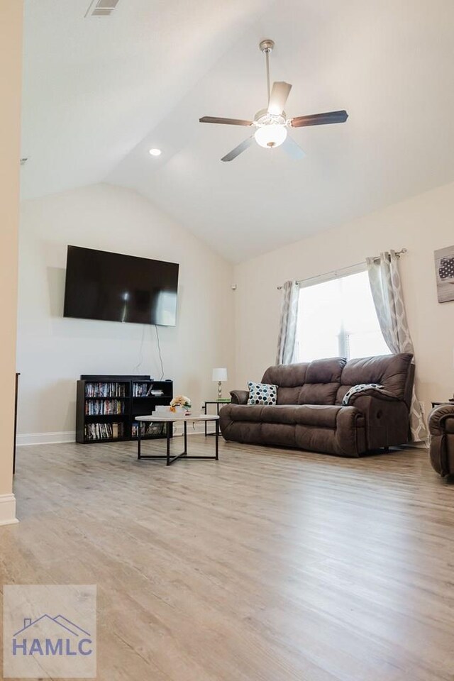 living room with ceiling fan, light hardwood / wood-style flooring, and lofted ceiling