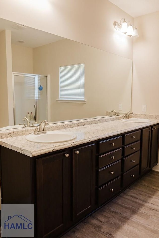 bathroom with hardwood / wood-style floors, vanity, and walk in shower