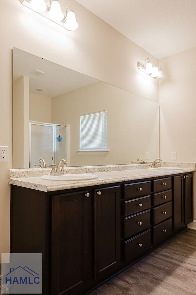 bathroom with vanity, hardwood / wood-style flooring, and a shower with door