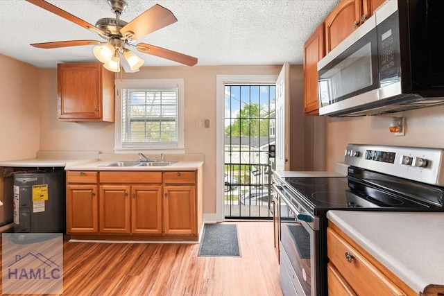 1514 Augusta Ave, Savannah, GA 31415 - kitchen featuring a sink, light countertops, brown cabinetry, stainless steel appliances, and light wood-style flooring