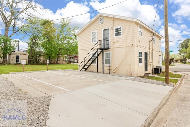 1514 Augusta Ave, Savannah, GA 31415 - exterior space featuring uncovered parking, stairway, fence, a front lawn, and central AC unit